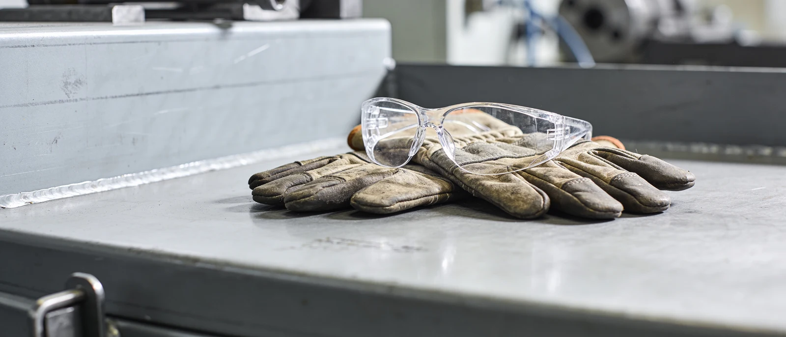 Arbeitshandschuhe und Schutzbrille auf der Werkbank